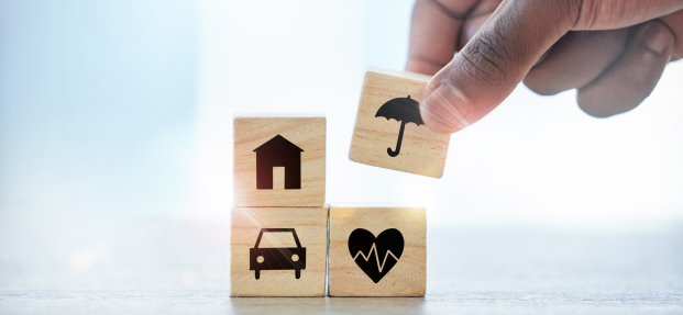 Stack of money and an umbrella, illustrating the cost of umbrella insurance.